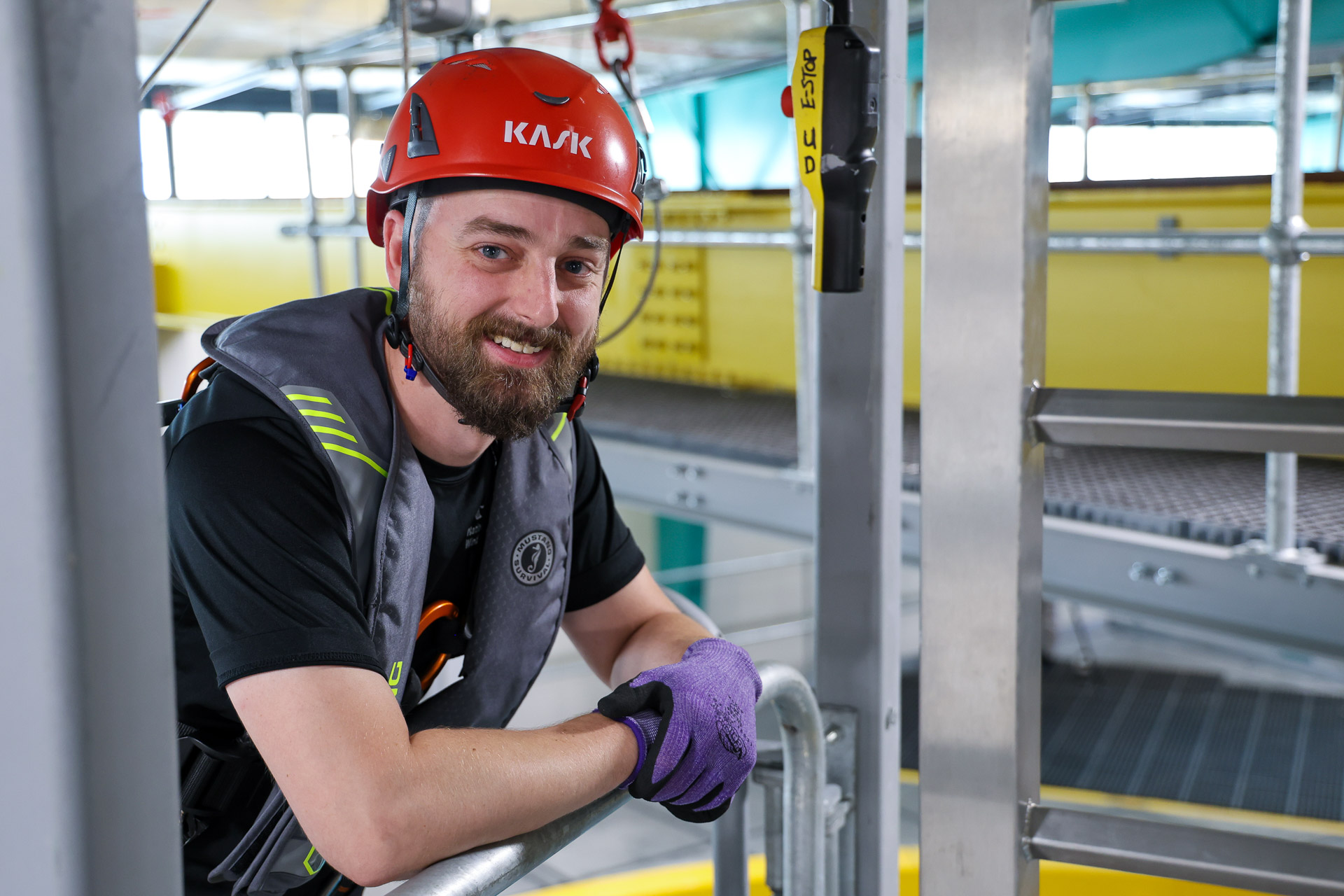 National Offshore Wind Institute trainer leaning on a railing, wearing protective gear.